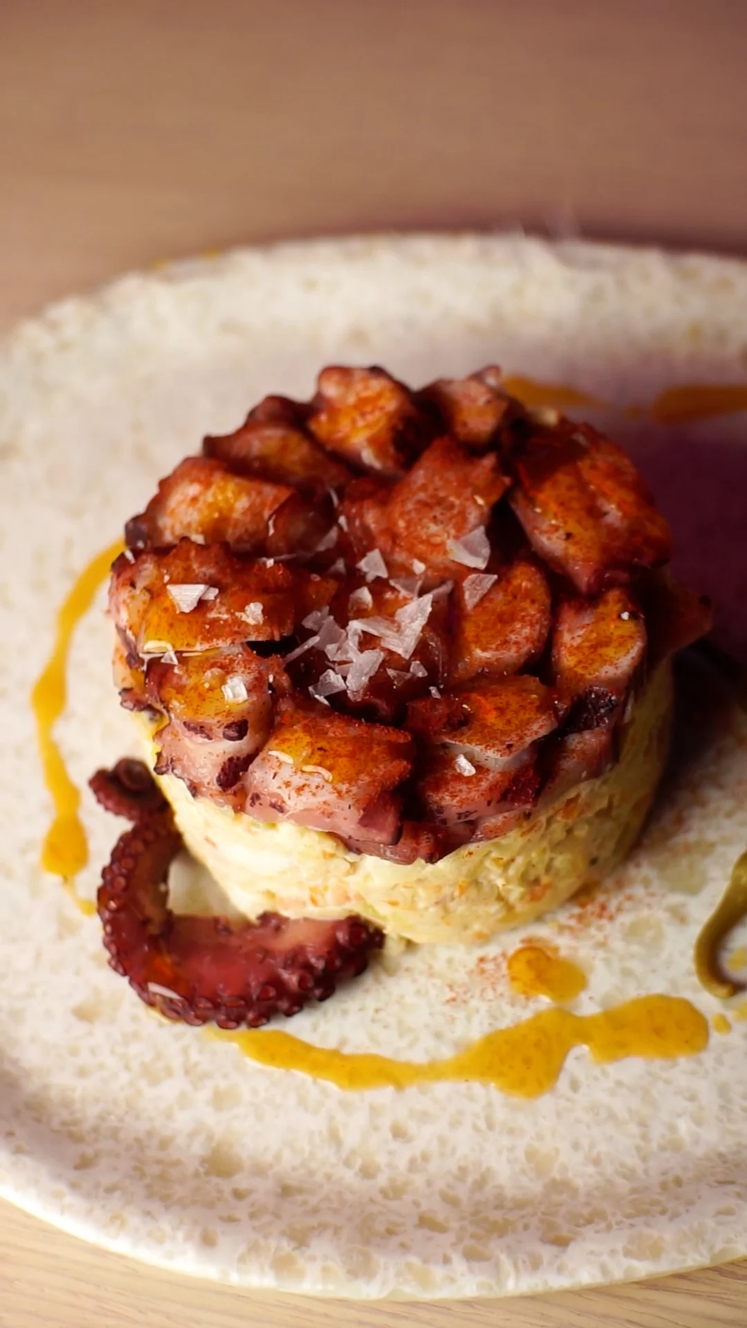 Traditional Russian salad with sliced ​​octopus, La Vera paprika and drops of Galician garlic sauce