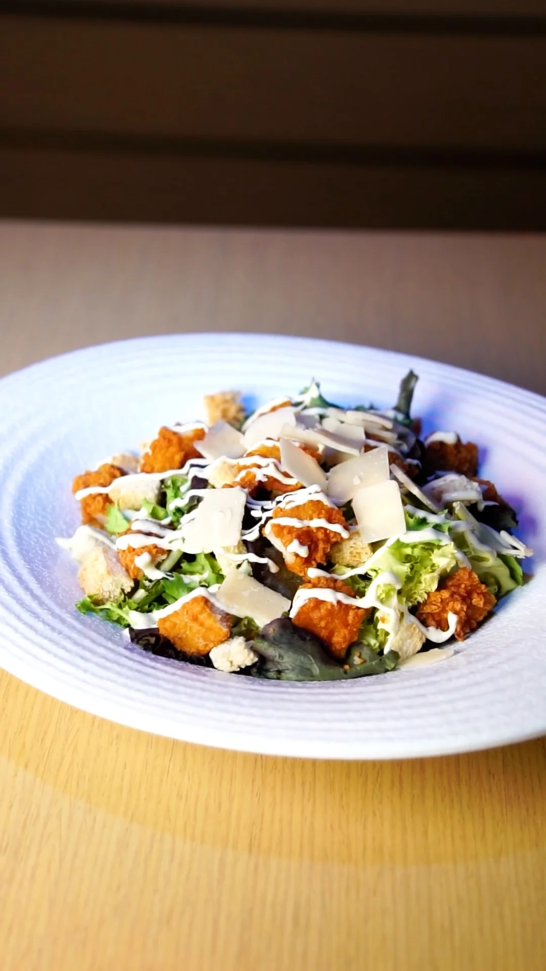 Leaves Caesar salada with crispy chicken, Parmigiano Reggiano shavings, croutons and a mild anchovy dressing