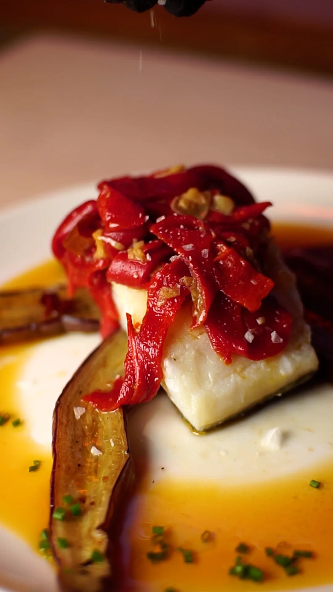 Roasted cod with red pepper Bilbao-style sauce on a bed of grilled Sichuan eggplant