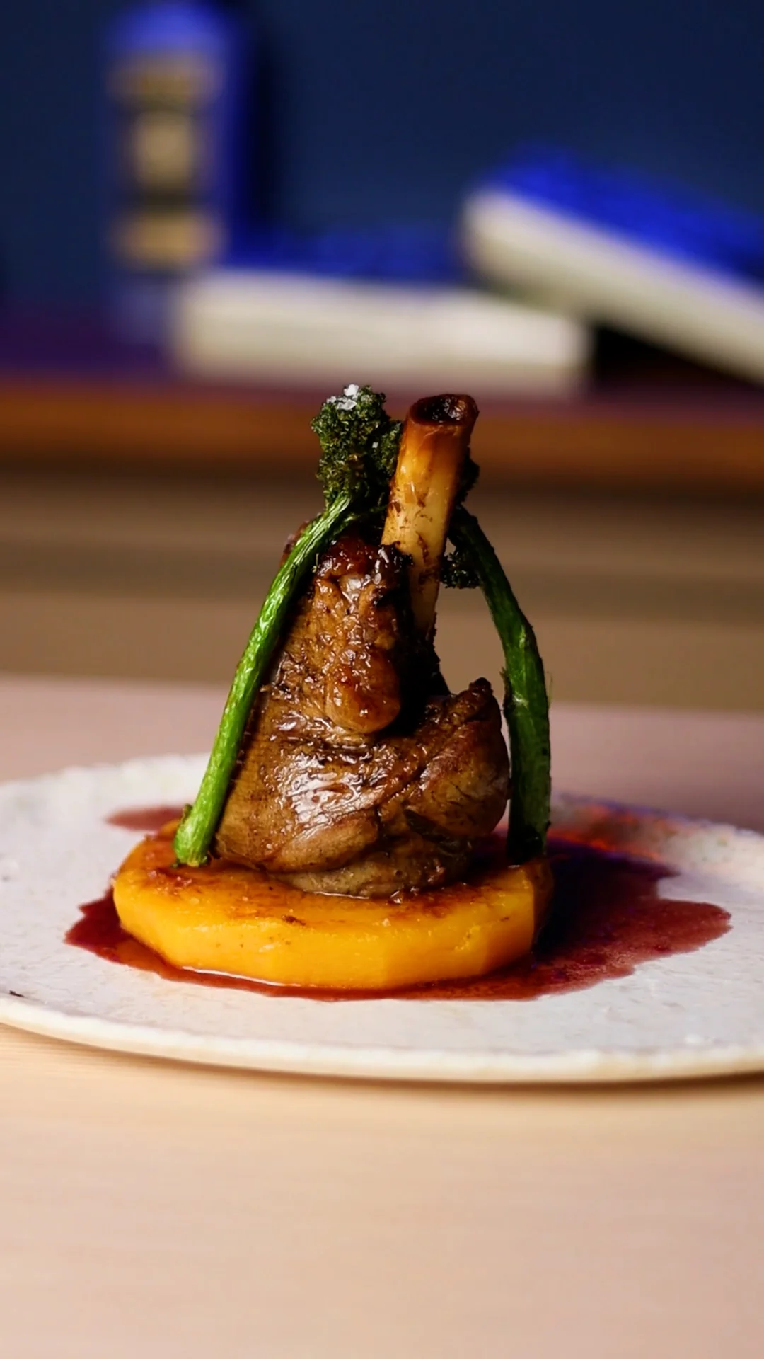 Braised Lamb Shank on Roasted Pumpkin Medallion, Port Wine Reduction and Crispy Bimi