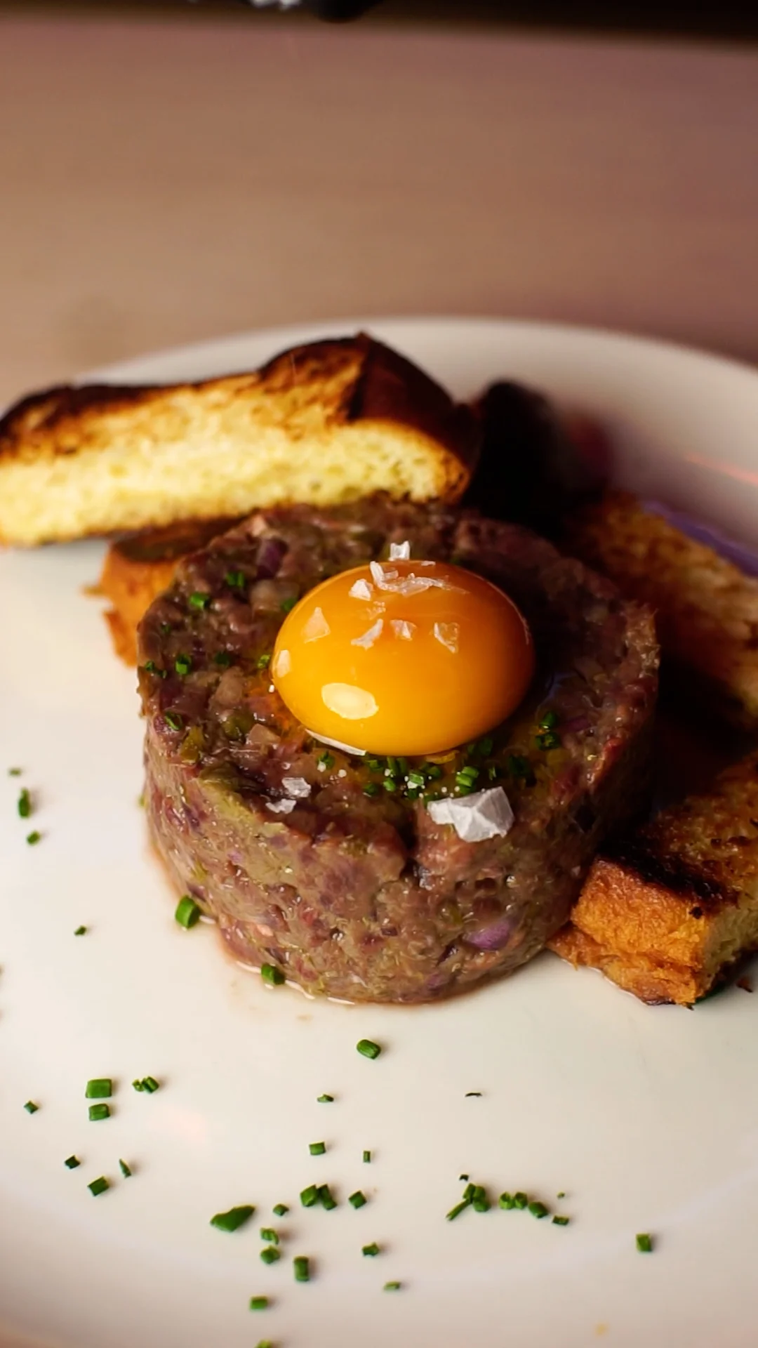 European elk steak tartare with its classic dressing, egg yolk and toasted brioche slices